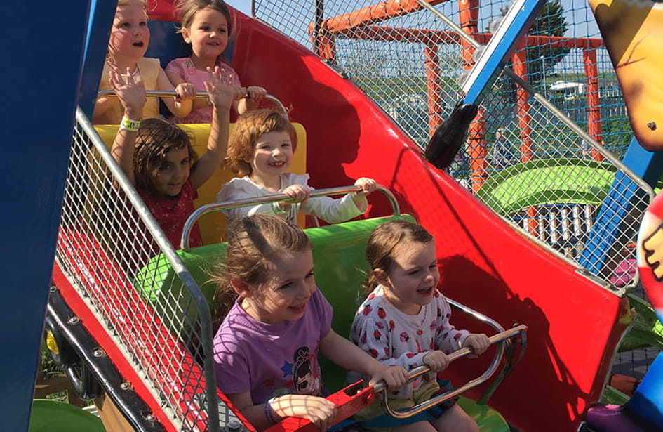 A group of children riding a ride at an amusement park.