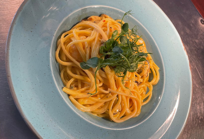 A plate of spaghetti with a garnish on it.