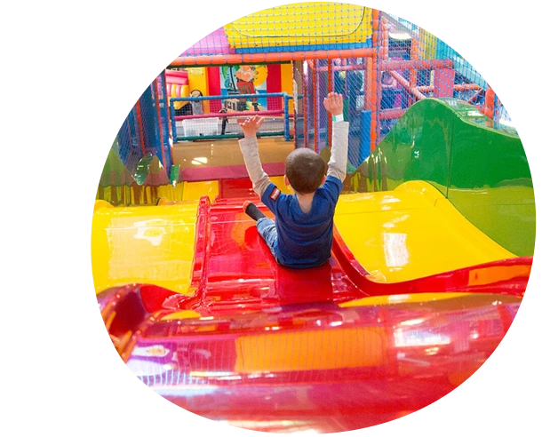A child is playing on a colorful slide at Fantasy Island Weymouth.