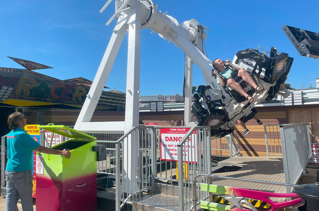 A man standing on a ride at an amusement park.