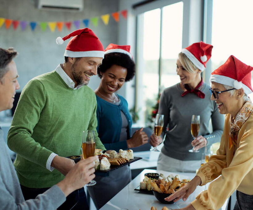 A group of people in santa hats at a christmas party.