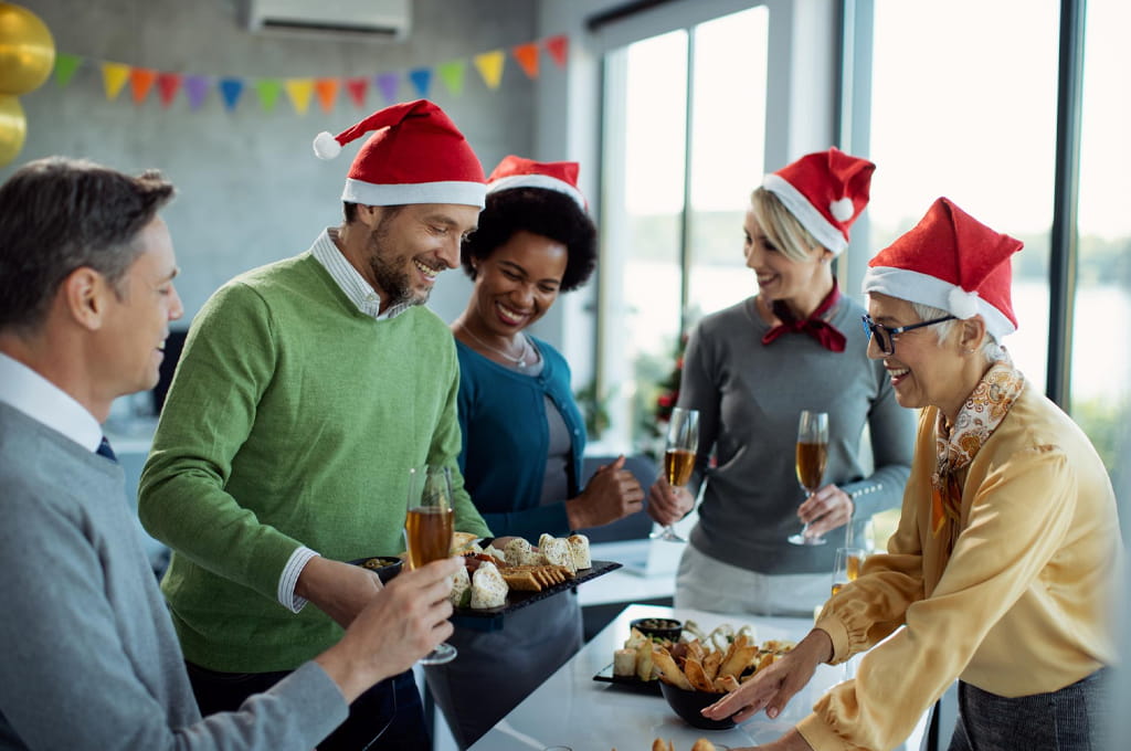 A group of people in santa hats at a christmas party.